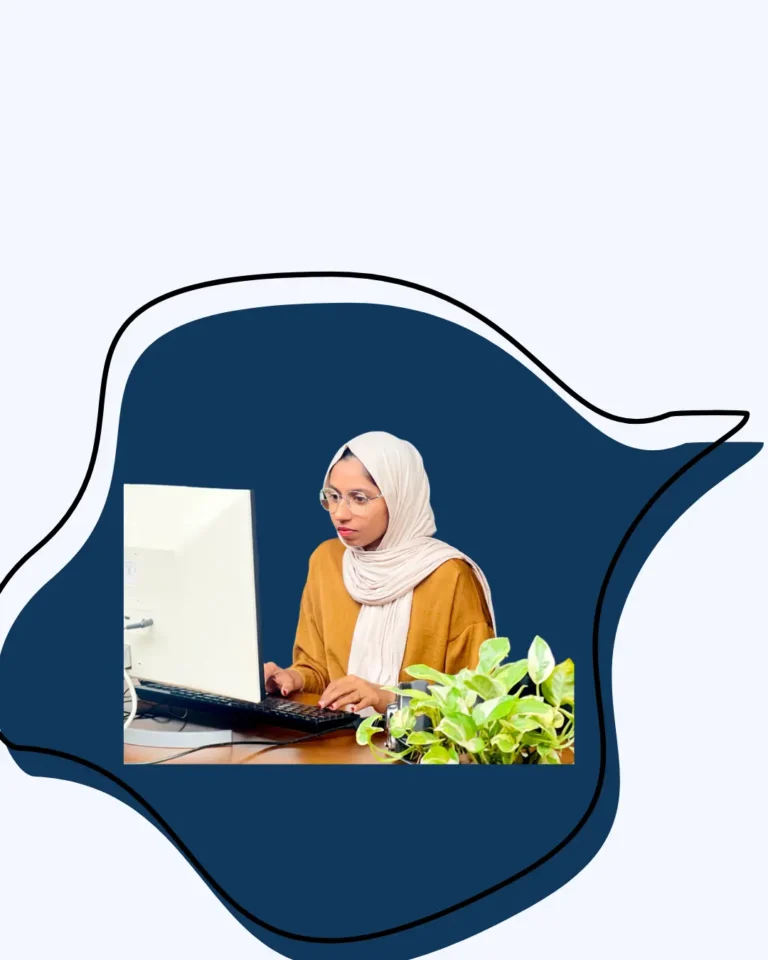 digital marketing strategist in abu dhabi digital marketing strategist in abu dhabi A woman wearing a hijab and glasses works on a computer at a desk with a green plant beside her.